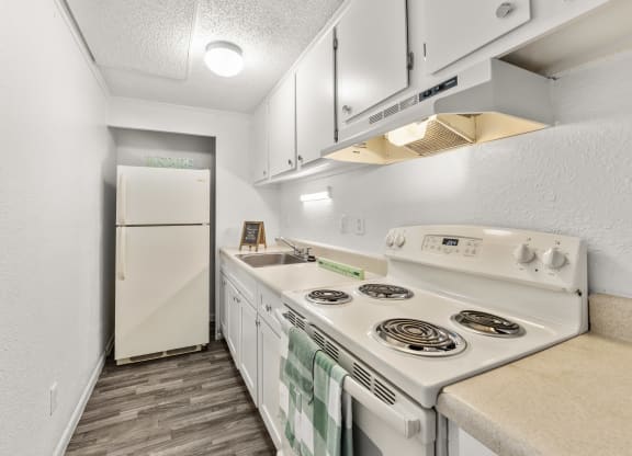 a kitchen with white appliances and a white refrigerator