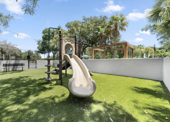 a playground with a slide and a swing set in a backyard