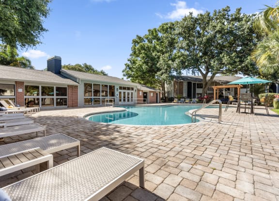 a swimming pool in front of a house with a resort style pool