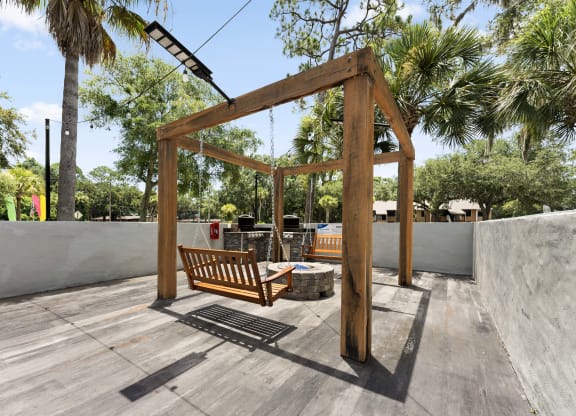 a swing bench in the backyard of a house