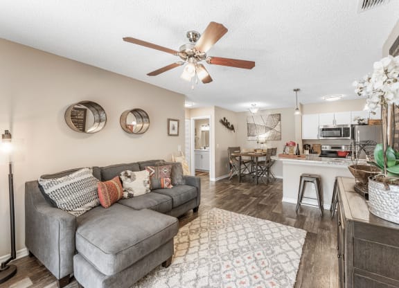 a living room with a couch and a ceiling fan