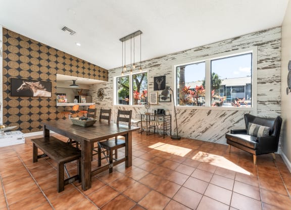 a dining room with a wooden table and chairs and a large window