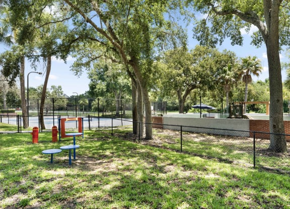 a park with a tennis court and a playground and trees