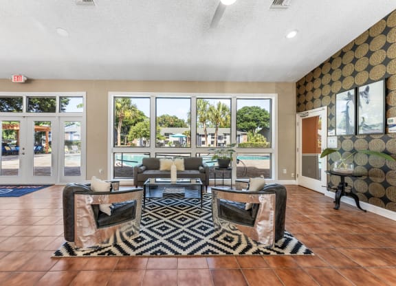 a living room with couches and chairs and a view of a pool