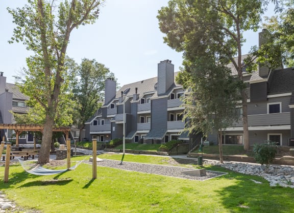 a view of an apartment community with hammocks and trees
