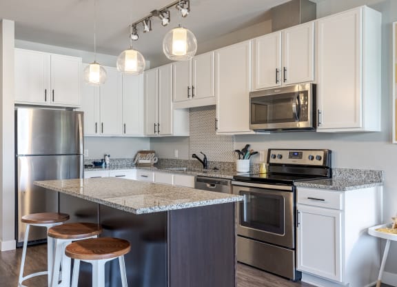 a kitchen with stainless steel appliances and an island with three stools