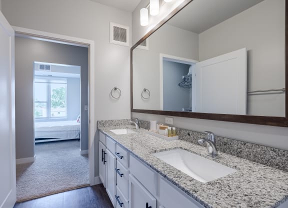 A bathroom with a sink, mirror, and a carpeted floor.
