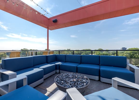 A blue sofa set is arranged on a patio with a table in the middle.