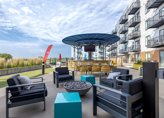 A patio with black furniture and a blue umbrella.