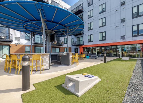 a courtyard with tables and chairs at a modern apartment building