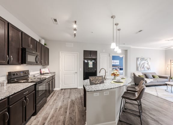 an open kitchen and living room with a large counter top