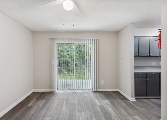 a spacious living room with a large window and a sliding glass door