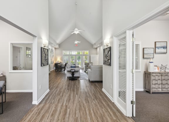 the living room and dining room of a house with white walls and wooden floors