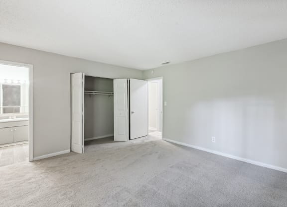 an empty living room with white walls and a closet