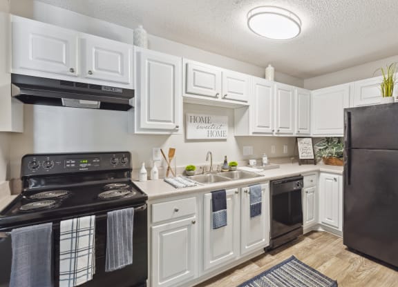the preserve at ballantyne commons apartment kitchen with black appliances and white cabinets