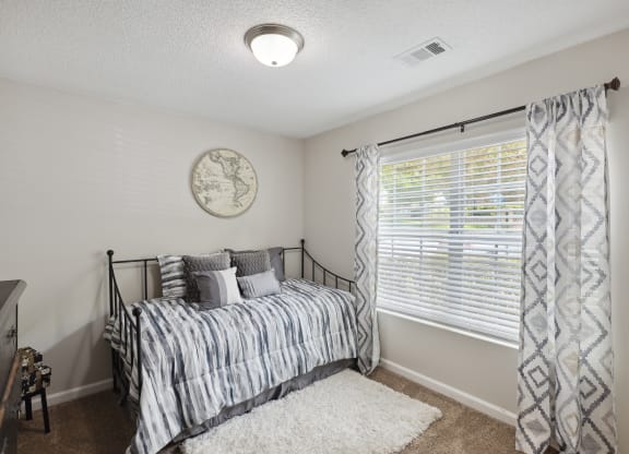 a bedroom with a bed and a large window