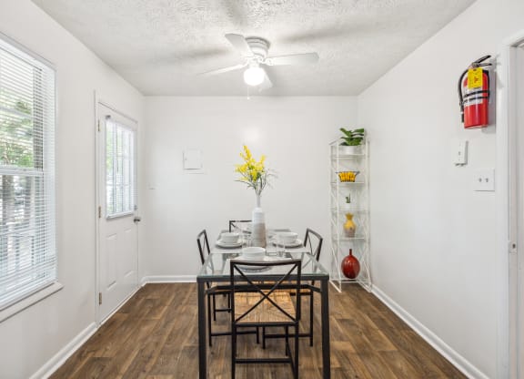 a dining room with a table and chairs and a ceiling fan