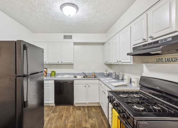 a kitchen with white cabinets and stainless steel appliances and a refrigerator