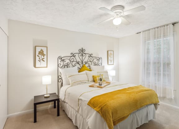 a bedroom with a bed and a ceiling fan
