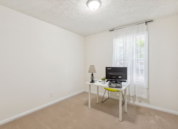 a living room with a desk and a television