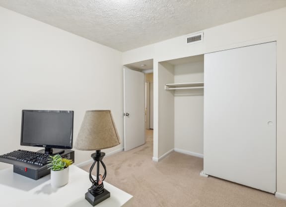 an office with a computer and a lamp on a desk