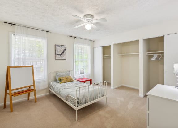 a bedroom with a bed and a ceiling fan
