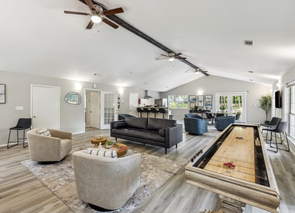 a living room with couches and chairs and a shuffleboard table