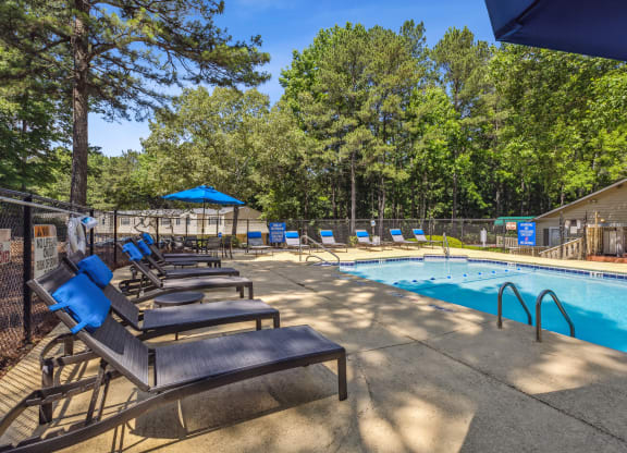 our resort style swimming pool is next to a row of lounge chairs