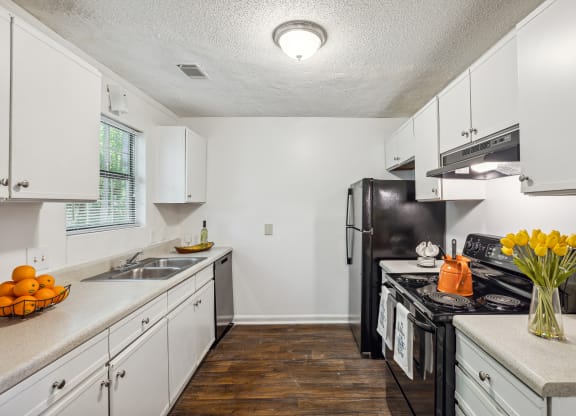 a kitchen with white cabinets and a black refrigerator