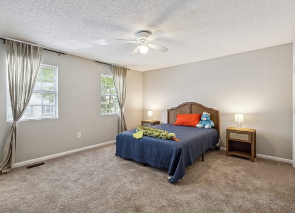 a bedroom with a bed and a ceiling fan
