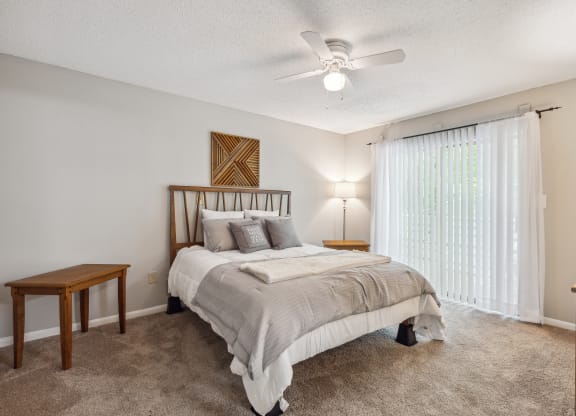 a bedroom with a bed and a ceiling fan