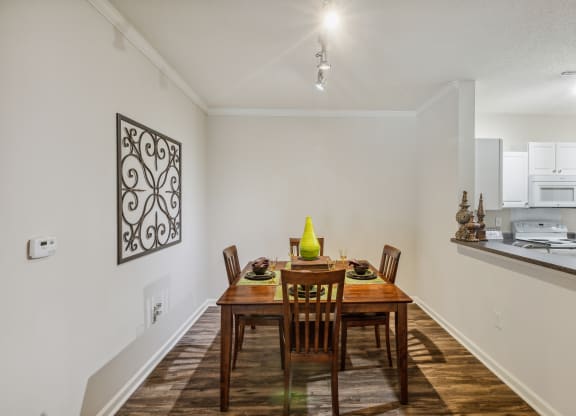a dining room with a wooden table and chairs and a kitchen