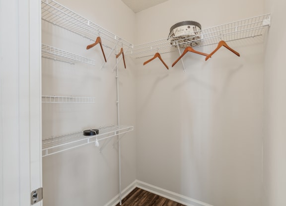 a spacious closet with shelves and hooks in a white room