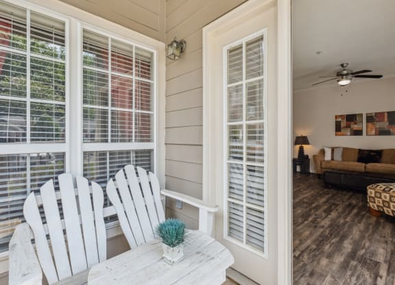 a living room with a table and chairs and windows