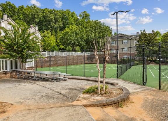 a tennis court with a fence around it and some trees