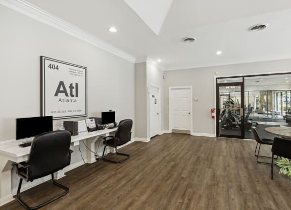 a white office with desks and chairs and a door to a store