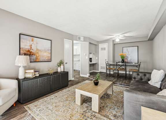 A living room with a white sofa, a coffee table, and a painting on the wall.