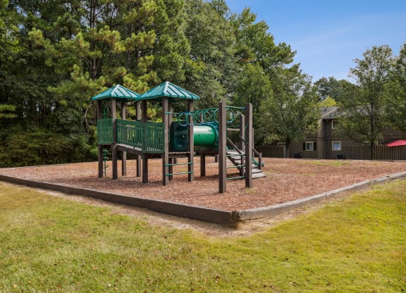A playground with a green roof and a slide.