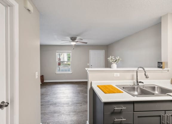 an empty kitchen with a sink and a ceiling fan