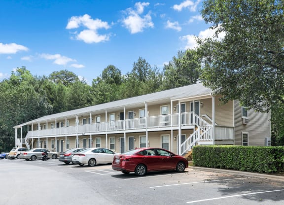 a parking lot with cars in front of an apartment building
