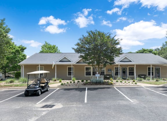 a clubhouse with a golf cart in the parking lot