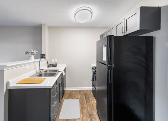 a kitchen with black appliances and a sink and refrigerator