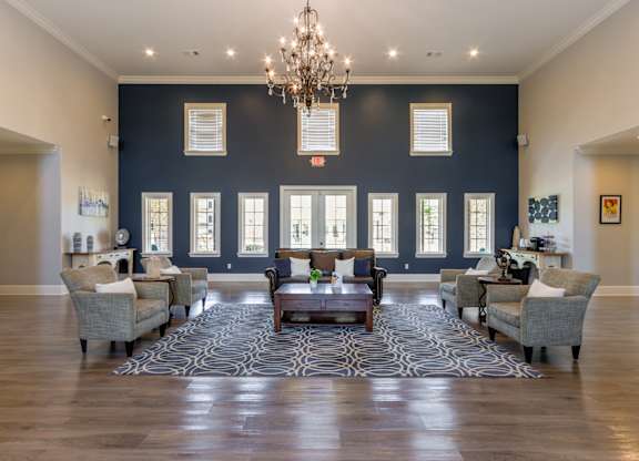 A large room with a chandelier, couches, and a rug.