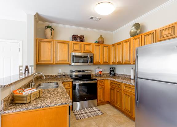 A kitchen with wooden cabinets and a stainless steel refrigerator.