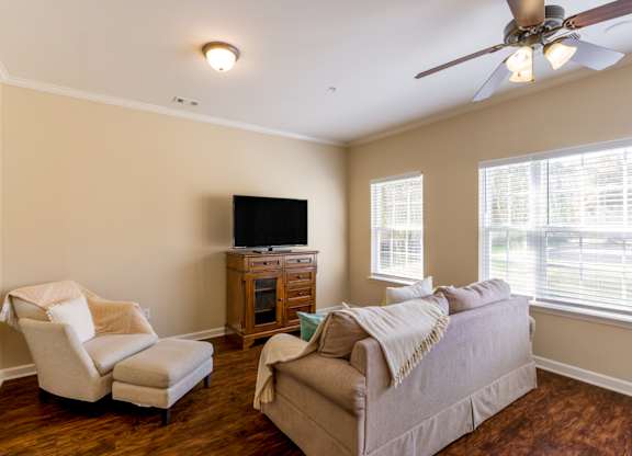 A living room with a couch, chair, and television.