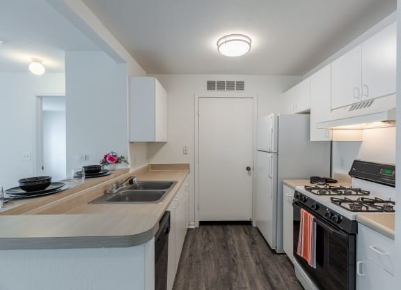 a kitchen with white cabinets and stainless steel appliances and a white refrigerator