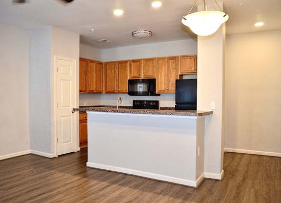 A kitchen with wooden cabinets and a white island.