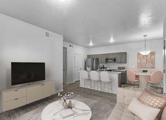 A living room with a television, a dining table, and chairs.