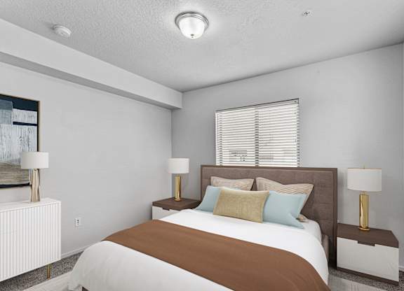 A bedroom with a large bed and two lamps.
