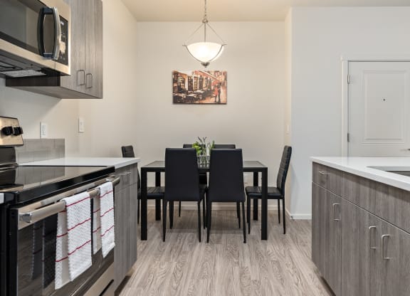A kitchen with a dining table and chairs.
